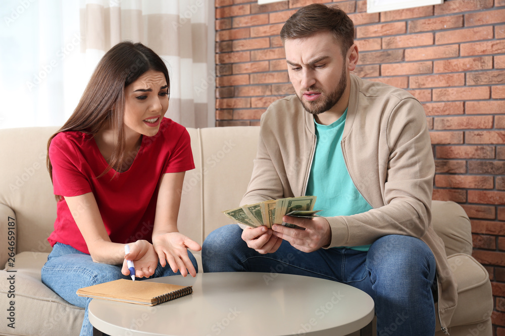 Unhappy young couple with money at home. Financial problems Unhappy young couple with money at home. Financial problems