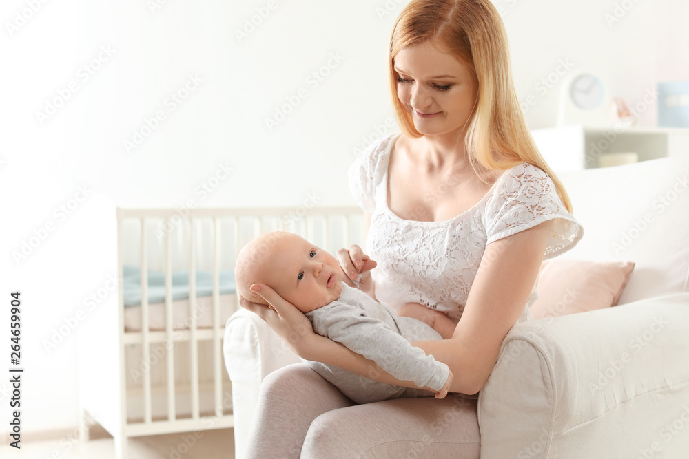 Happy mother with her baby sitting in armchair at home Happy mother with her baby sitting in armchair at home