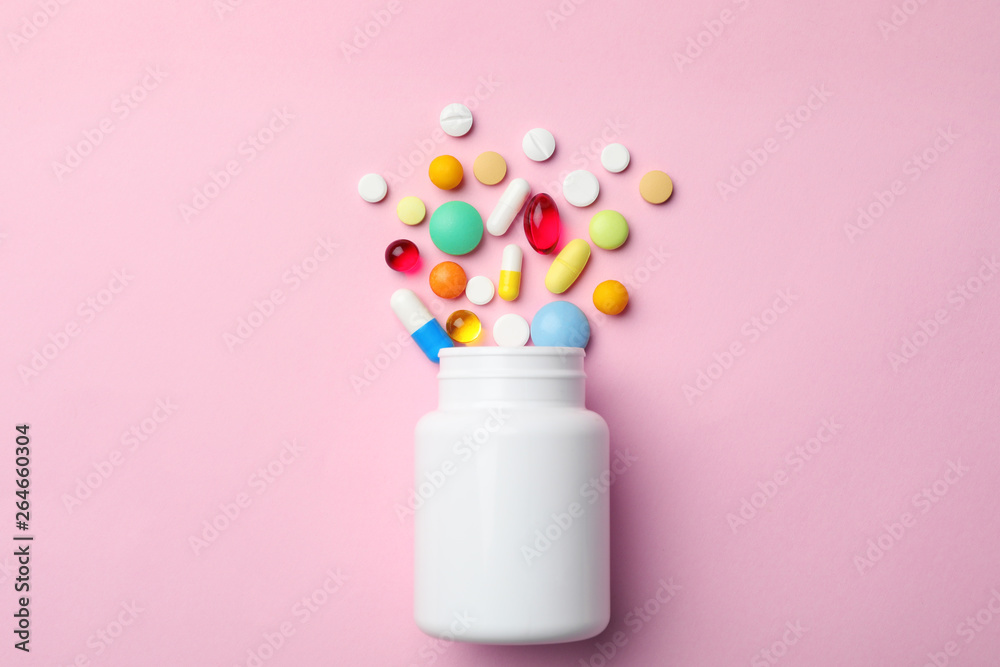 Bottle with different pills on color background, flat lay Bottle with different pills on color background, flat lay