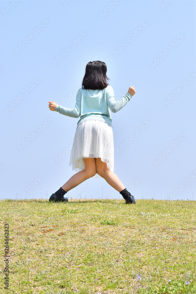 青空でポーズをきめる女の子 後姿 Stock 写真 Adobe Stock