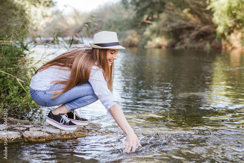 Fototapeta Naklejka Na Ścianę i Meble -  Blonde woman enjoys water in a lake