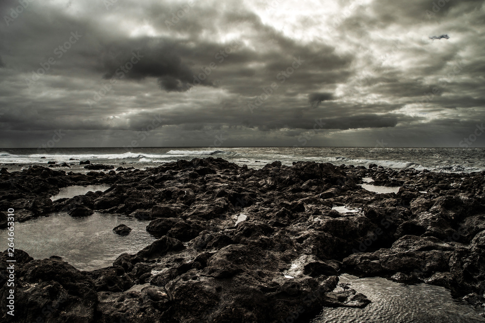 beautiful view from a stony shore to a raging ocean.