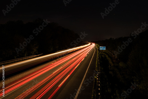 Langzeitbelichtung auf der Autobahn. Nachtlichter, Stadtlichter, Geschwindigkeit, Transport, Traffic, Autos in Bewegung, Fahrbahn, Road