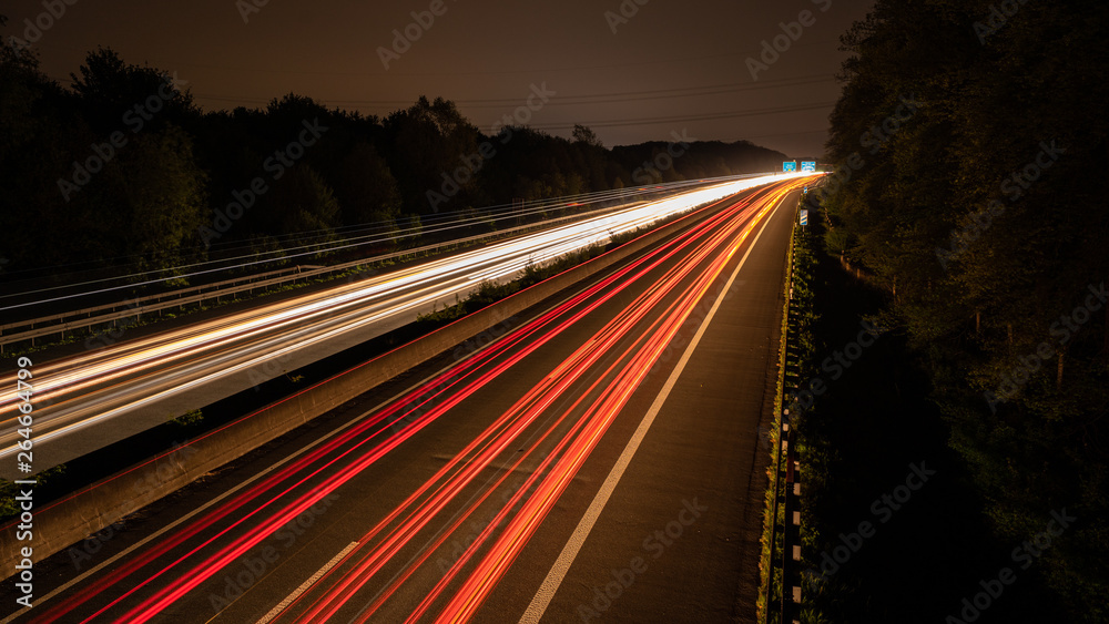 Langzeitbelichtung auf der Autobahn. Nachtlichter, Stadtlichter, Geschwindigkeit, Transport, Traffic, Autos in Bewegung, Fahrbahn, Road