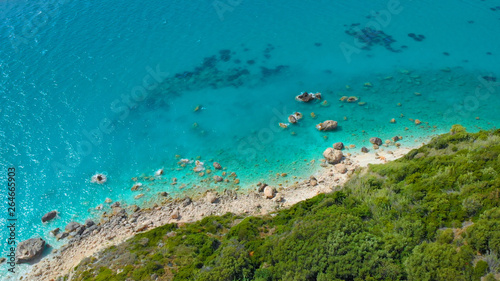 AERIAL: Flying above the untouched rocky shore covered by Mediterranean greenery