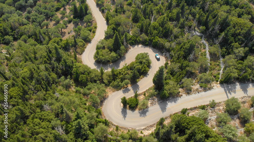 TOP DOWN  Flying above the blue SUV navigating the hairpin turns in Lefkada.