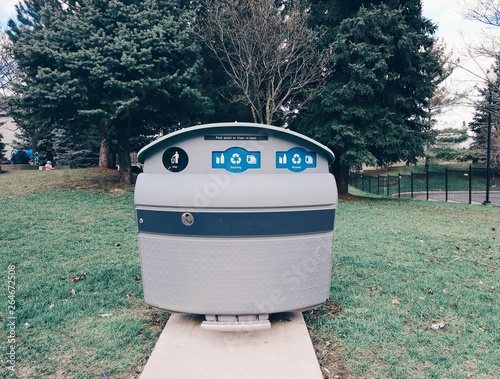 Photography Toronto, Ontario, Canada - April 24, 2019: Gray trash litter bin with recycle signs in green Toronto street park