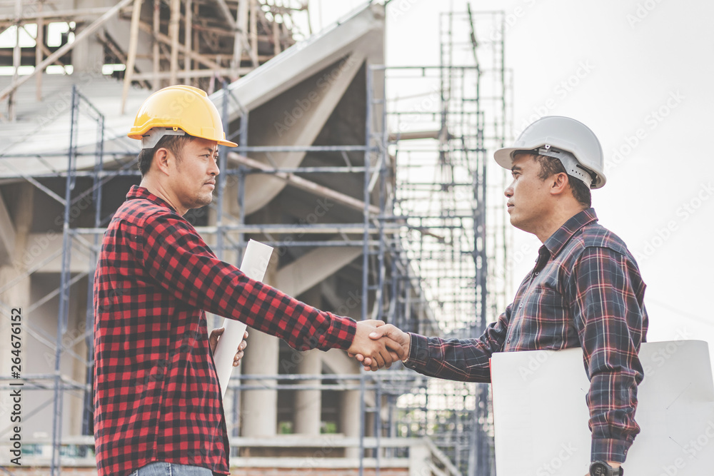 Two male engineer industry stands shake hands with the team and construction contract business Two male engineer industry stands shake hands with the team and construction contract business