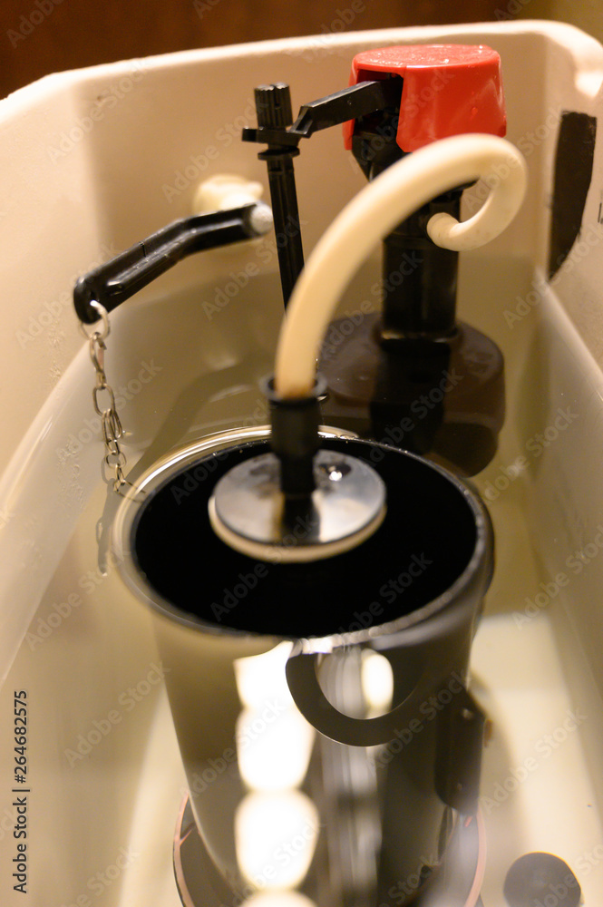 Inside water tank of toilet with float raised Inside water tank of toilet with float raised