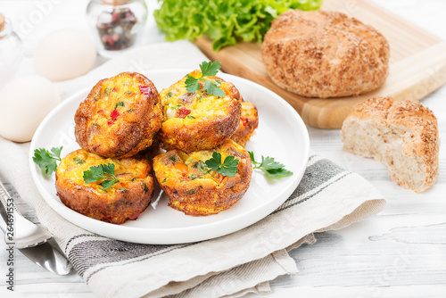Delicious egg muffins with meat, cheese and vegetables .