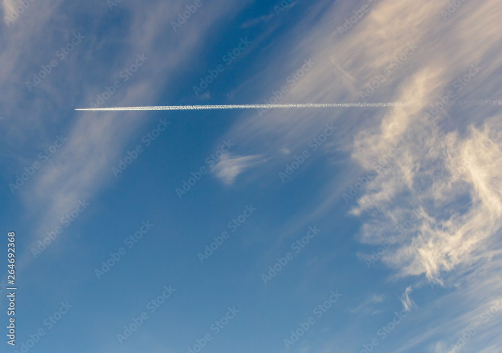 Trail from the plane in the sky at sunset Trail from the plane in the sky at sunset