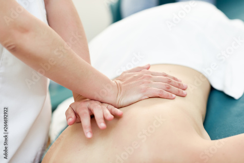 Young woman receiving a back massage by professional therapist.