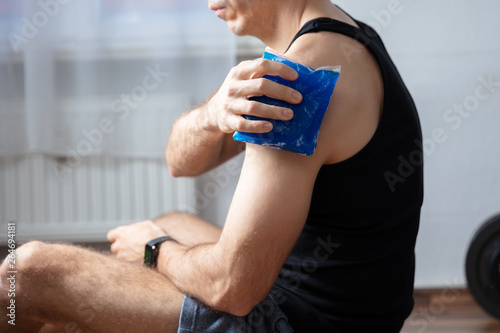 Man Applying Cool Gel Pack On His Shoulder photo