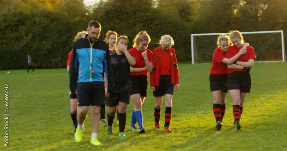 4K Losing girls' soccer team walking unhappily off pitch at the end of a game. Slow motion. 4K Losing girls' soccer team walking unhappily off pitch at the end of a game. Slow motion.
