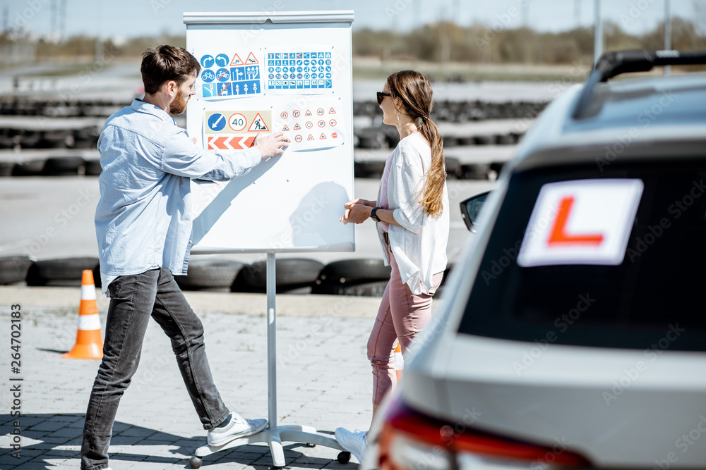 Male instructor showing traffic signs to a young female student ...
