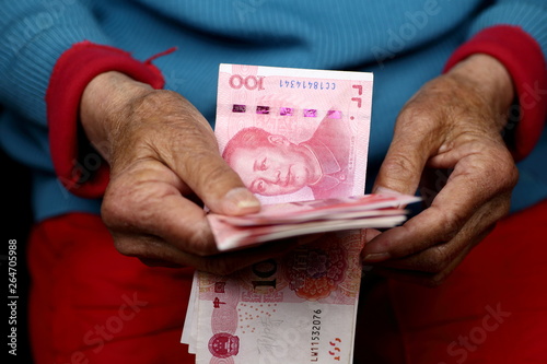 Konstfotografi Elderly woman's hands counting Chinese Yuan banknotes, close up