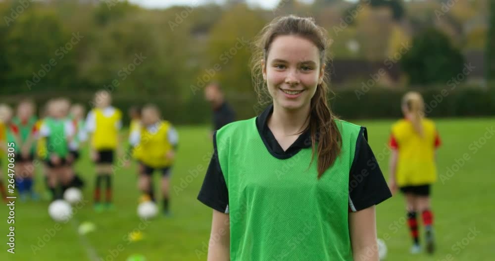 4K Portrait smiling British girl at soccer training, with team mates in the background. Slow motion. 4K Portrait smiling British girl at soccer training, with team mates in the background. Slow motion.