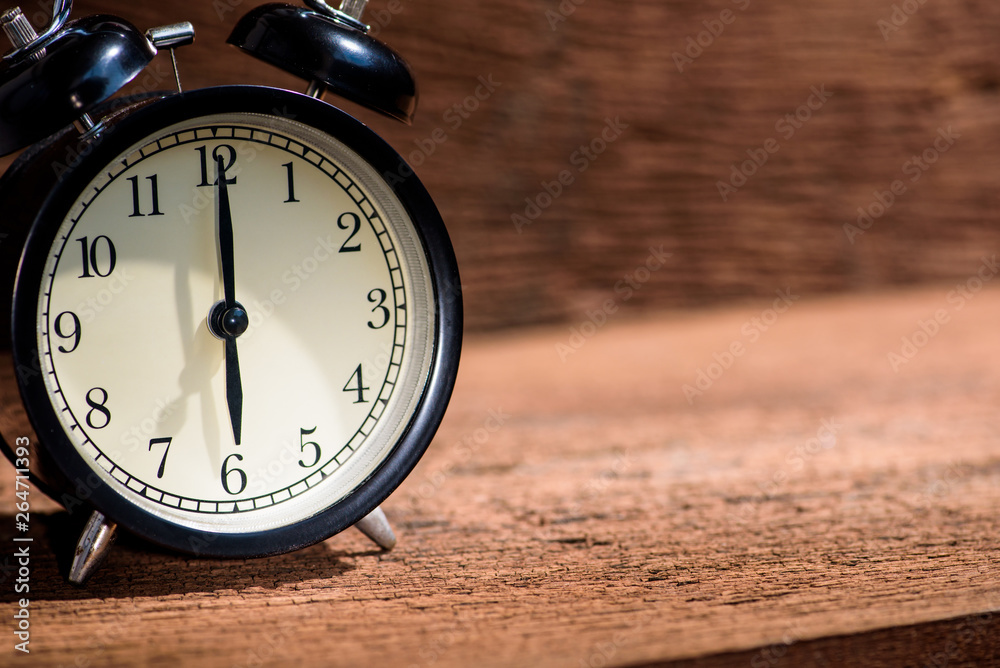 black alarm clock on wood table with sunrise light black alarm clock on wood table with sunrise light