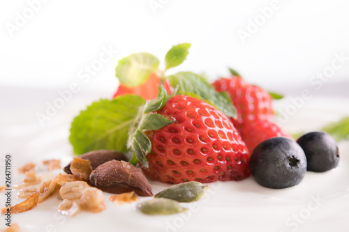 Plain yogurt with fresh berry fruits on top isolated on white background