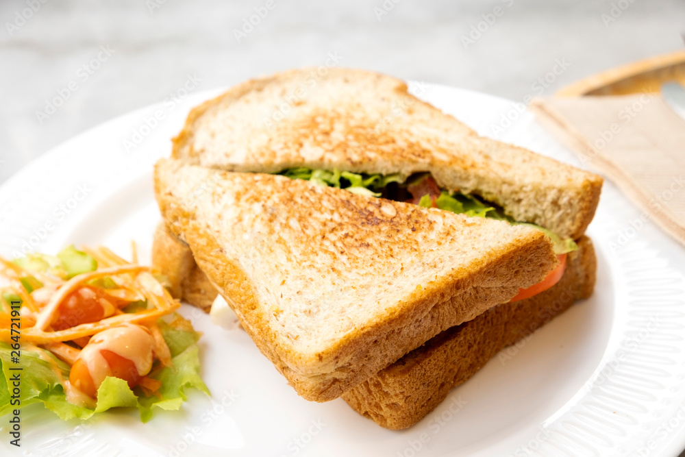 Breakfast, sandwiches, bacon and cheese and vegetables on the marble table Breakfast, sandwiches, bacon and cheese and vegetables on the marble table