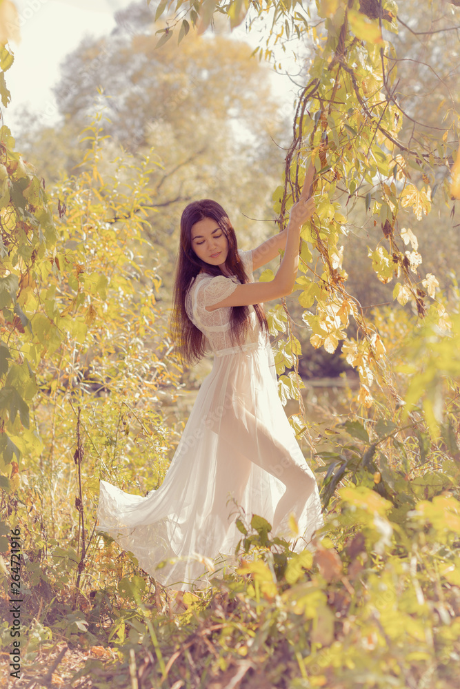 Portrait of a girl in a white dress on nature