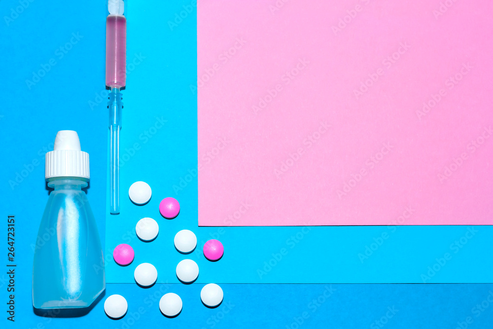 Medical stuff and pills minimalistic flat lay with copy space on a paper background of blue and pink. Medical stuff and pills minimalistic flat lay with copy space on a paper background of blue and pink.