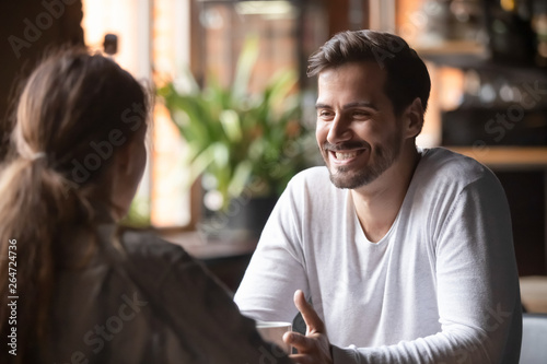 Bild auf Leinwand Rear view female sitting at speed dating with smiling man