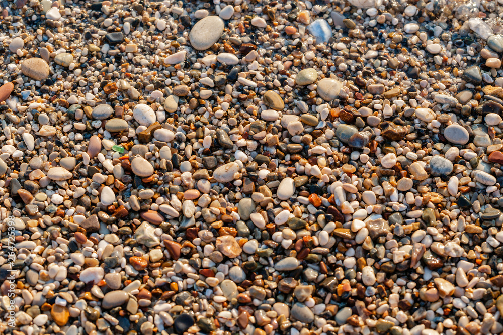 Close up beach stones on the seashore. Summer sunrise on coast, Corfu island, Greece. Beach Ionian sea. Wallpaper Close up beach stones on the seashore. Summer sunrise on coast, Corfu island, Greece. Beach Ionian sea. Wallpaper
