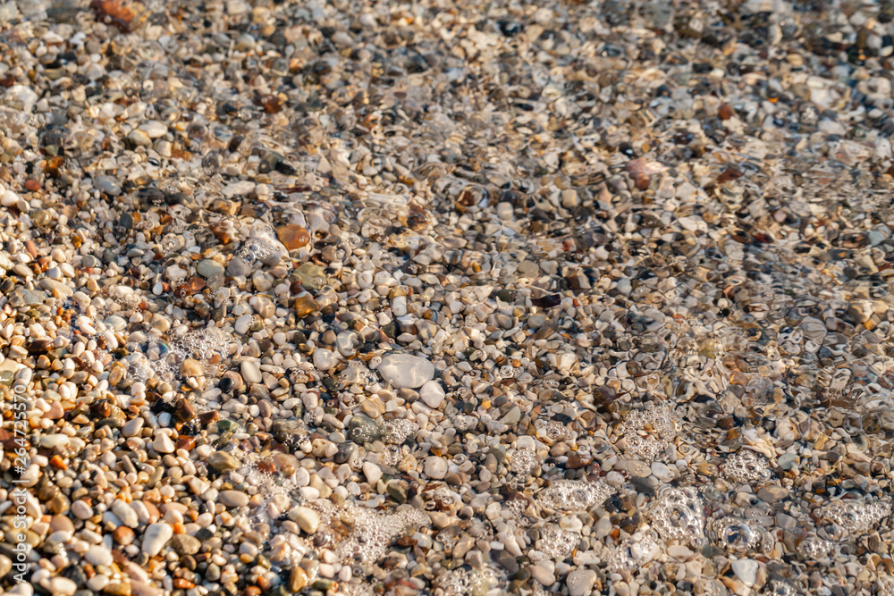 Close up under water beach stones on the seashore. Summer sunrise on coast, Corfu island, Greece. Beach Ionian sea. Wallpaper Close up under water beach stones on the seashore. Summer sunrise on coast, Corfu island, Greece. Beach Ionian sea. Wallpaper