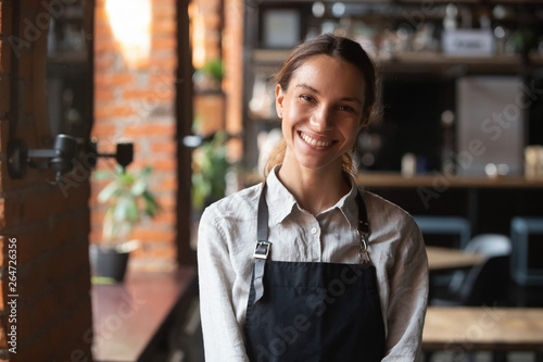 Obraz na plátne Happy mixed race female in apron smiling looking at camera