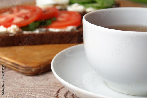 sandwiches with cottage cheese sour cream cheese greens vegetables and a Cup of tea with rose hips