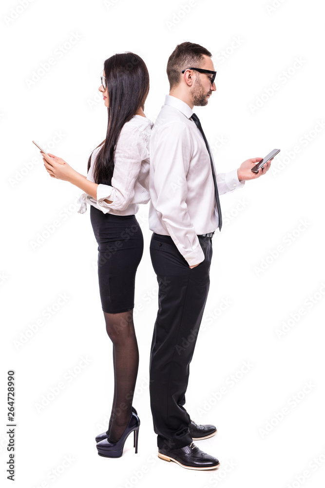 Young business man and business woman standing back to back and use their mobile phone isolated on white background Young business man and business woman standing back to back and use their mobile phone isolated on white background
