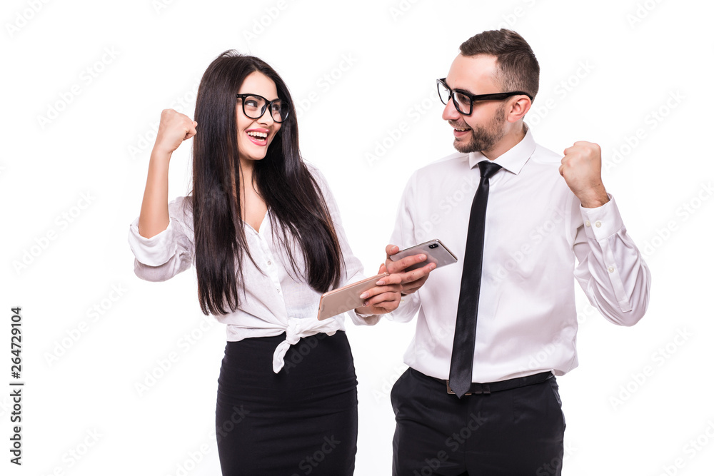 Portrait of young happy business colleagues couple isolated over white wall background using mobile phones make winner gesture.