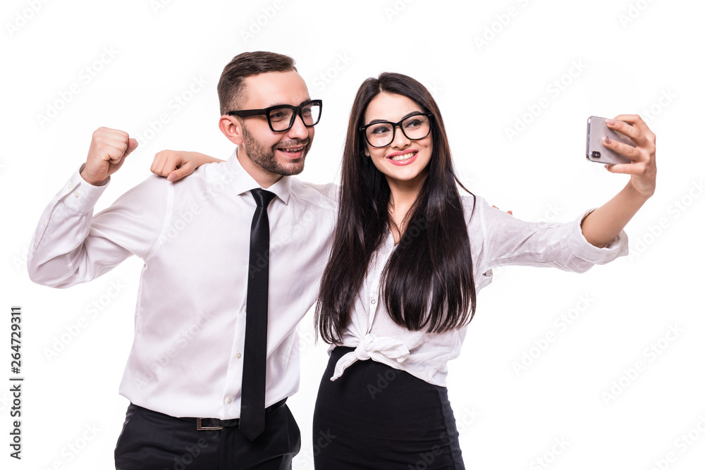 Photo of happy business colleagues couple showing thumbs up gesture take selfie isolated over white wall background. Photo of happy business colleagues couple showing thumbs up gesture take selfie isolated over white wall background.
