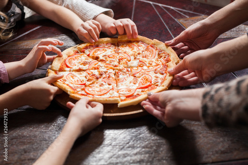 children eat pizza in a restaurant.