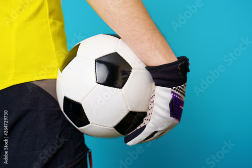 Man is socccer fan in yellow t-shirt with soccer ball