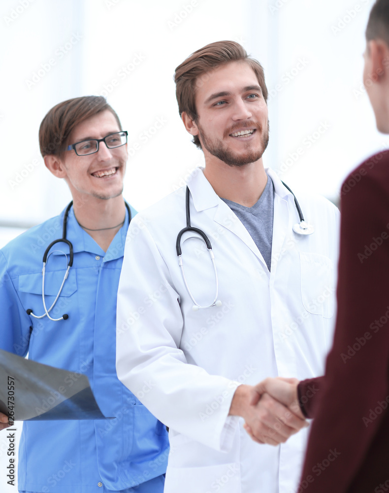 smiling doctor shaking hand of a patient smiling doctor shaking hand of a patient