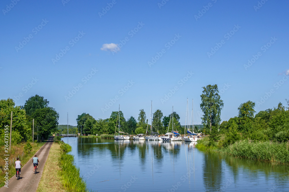 Boats in a canal and cyclists on the canal path Boats in a canal and cyclists on the canal path