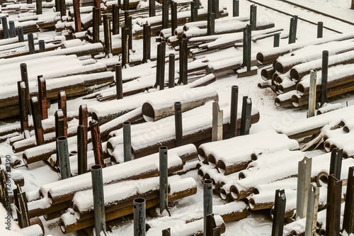 Outdoors industrial warehouse of finished steel pipes and metal products. Storage site at winter time. photo