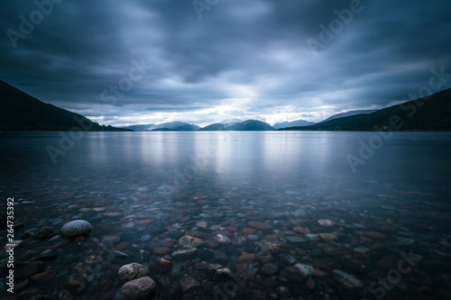 Fototapeta Naklejka Na Ścianę i Meble -  Mystic landscape lake scenery in Scotland: Cloudy sky, sunbeams and mountain range in loch Linnhe