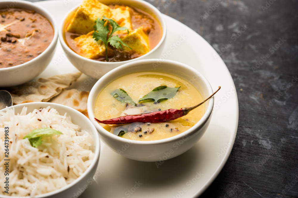 Indian vegetarian platter / Thali having Palak paneer butter masala, dal makhani, flat bread or naan and rice served in a white plate Indian vegetarian platter / Thali having Palak paneer butter masala, dal makhani, flat bread or naan and rice served in a white plate