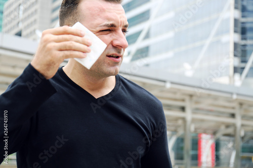 Sport man exercise Outdoor fitness hot and tired on walking street, Building office background.