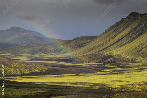 Dramatic iceland landscape with a green hill and black lava looks like a moon. Serenity of Iceland.