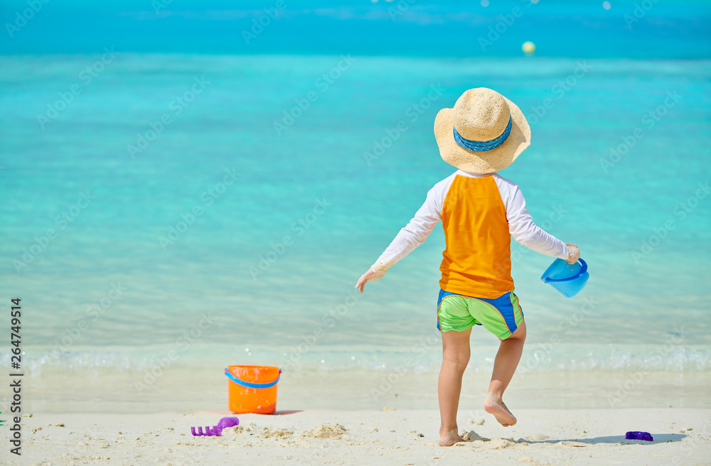 Three year old toddler playing on beach Three year old toddler playing on beach