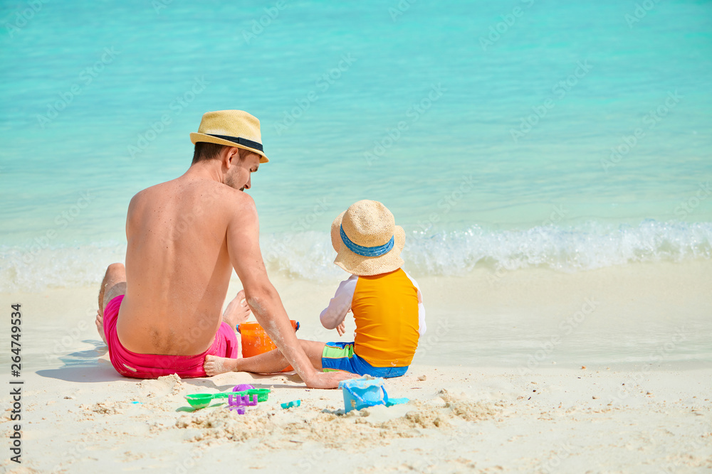 Toddler boy on beach with father Toddler boy on beach with father