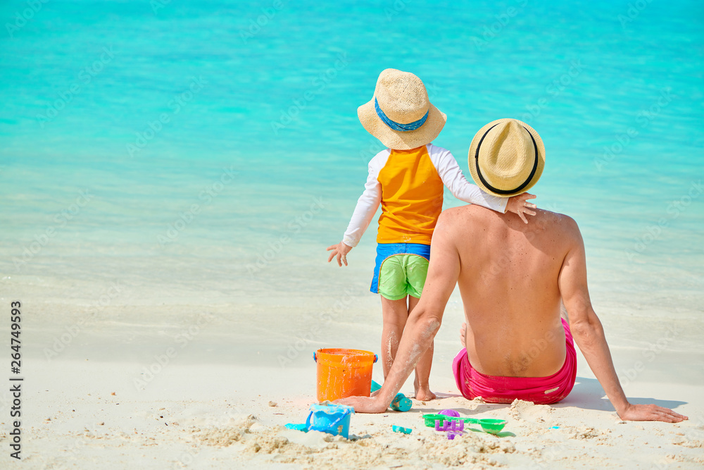 Toddler boy on beach with father