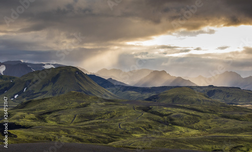 Dramatic iceland landscape with a green hill and black lava looks like a moon. Serenity of Iceland.