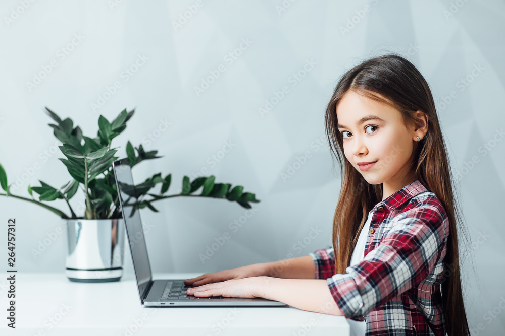 Little girl sitting at table and using modern tablet ! Homework! Little girl sitting at table and using modern tablet ! Homework!