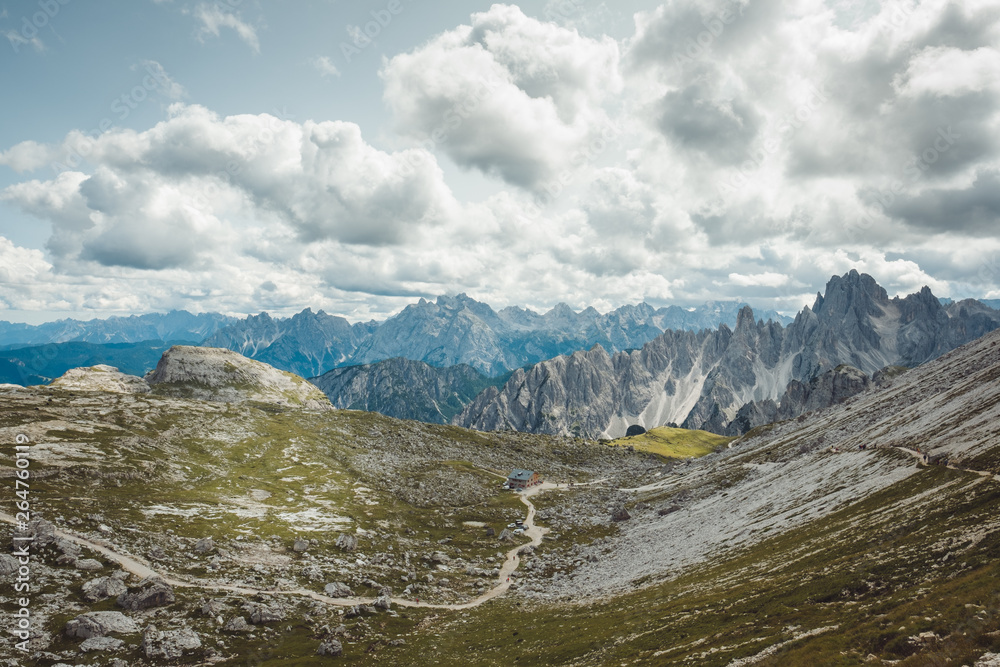 Schronisko górskie i błękitne niebo nad górską doliną i szlakiem  Tre Cime di Lavaredo