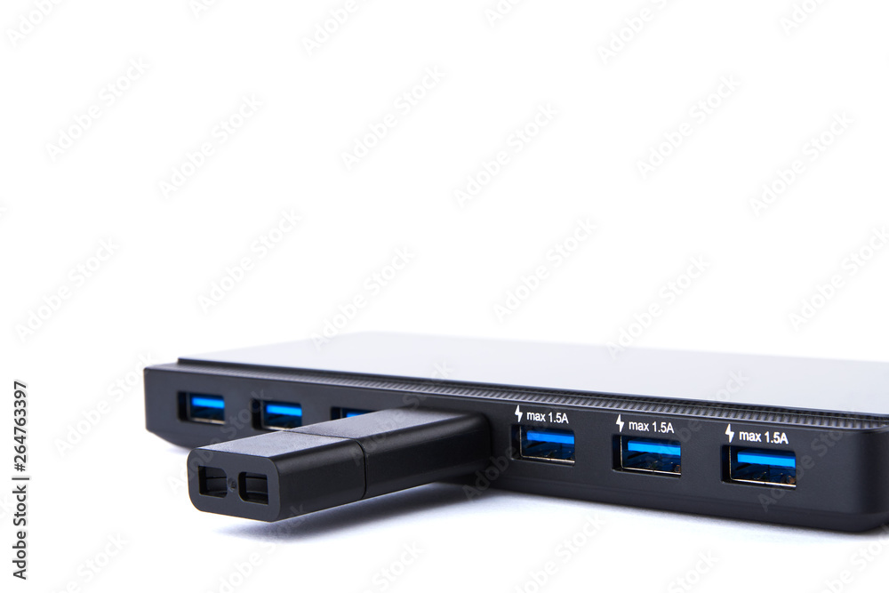 Detailed view of black USB hub with many ports, charging and flash drive with silver blue connector. On white background with space for your text. Detailed view of black USB hub with many ports, charging and flash drive with silver blue connector. On white background with space for your text.